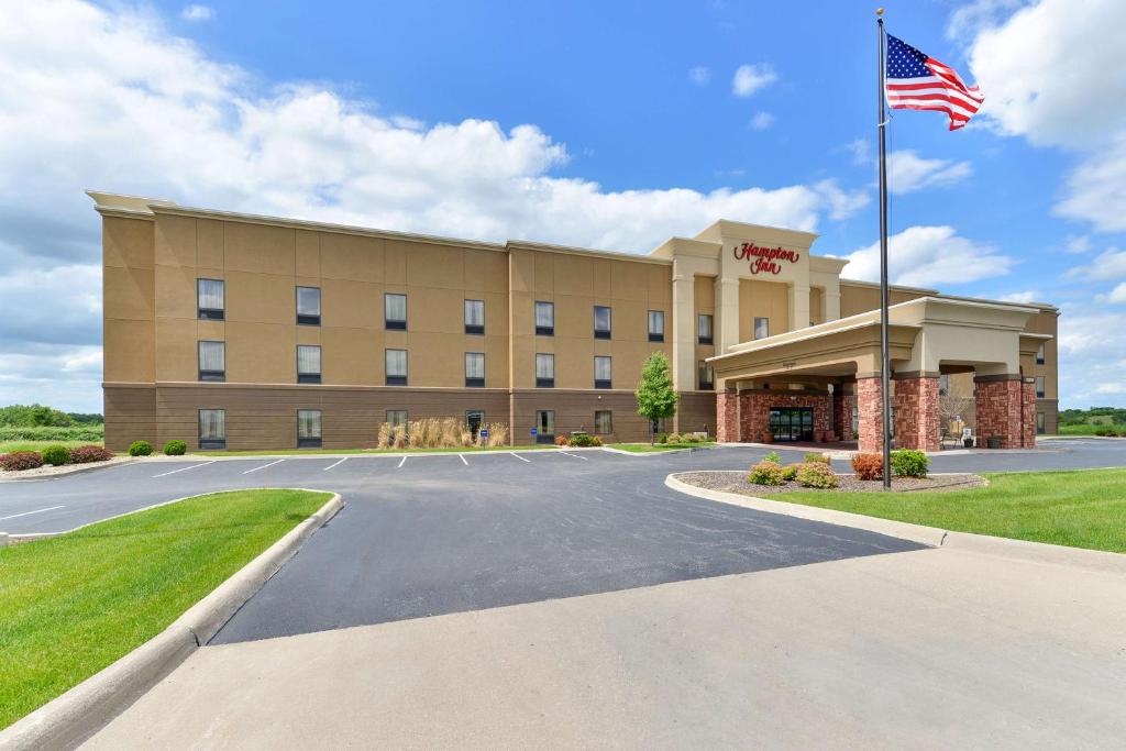 ein Hotel mit amerikanischer Flagge davor in der Unterkunft Hampton Inn Muscatine in Muscatine