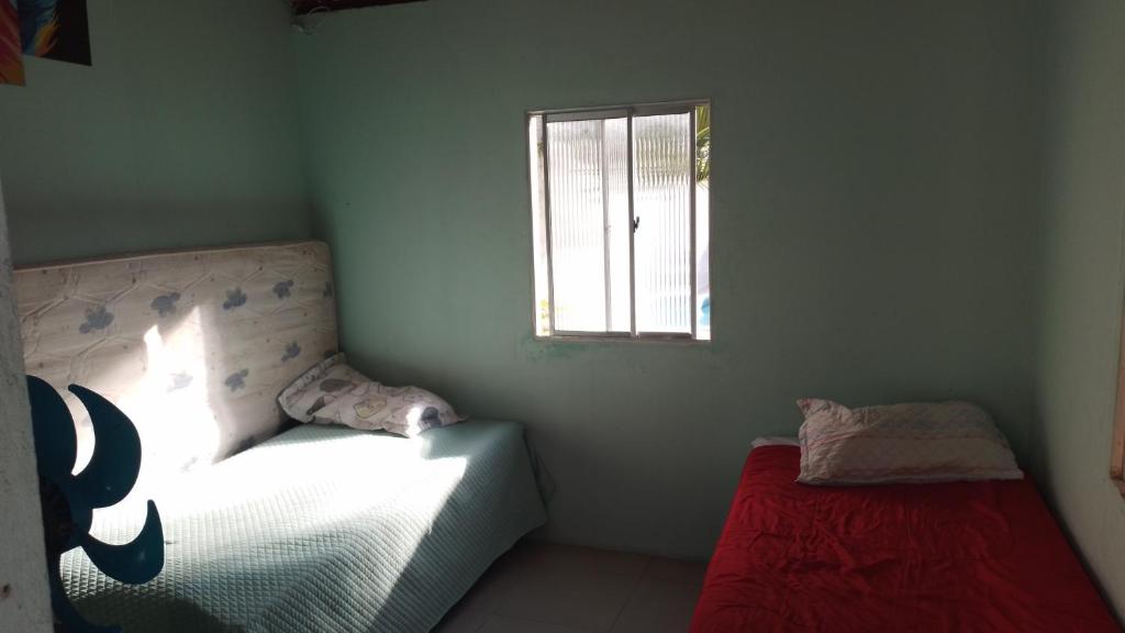 een kleine slaapkamer met een bed en een raam bij CASA DE TEMPORADA RECANTO FELIz 2 in Aracaju