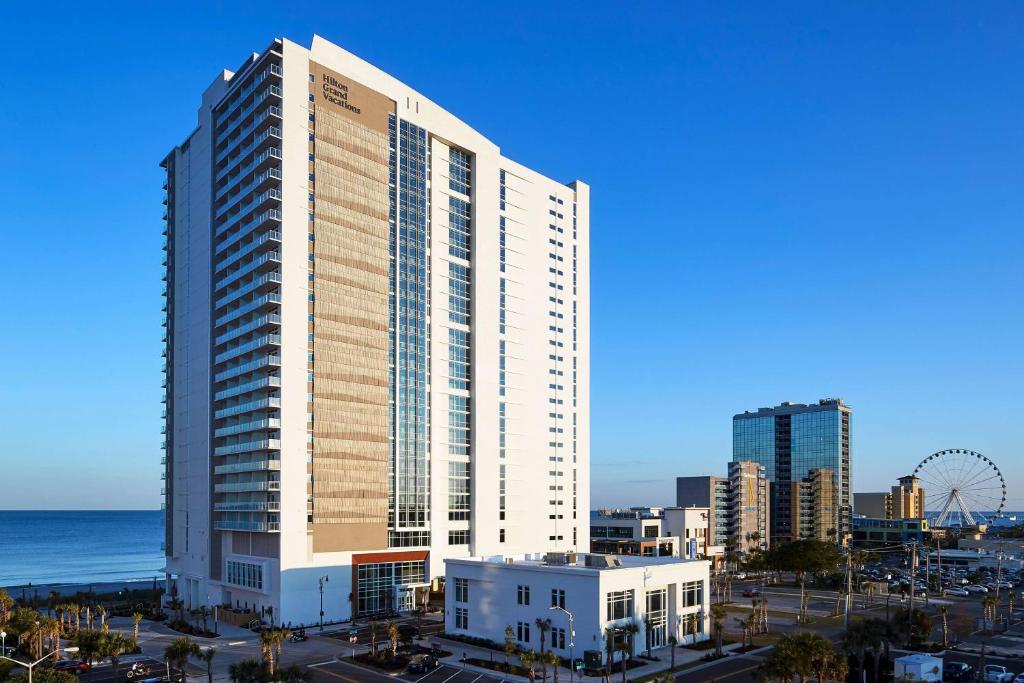 ein hohes Gebäude vor dem Meer und einer Stadt in der Unterkunft Hilton Grand Vacations Club Ocean Enclave Myrtle Beach in Myrtle Beach