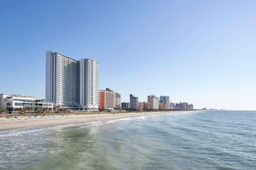 Blick auf einen Strand mit hohen Gebäuden und das Meer in der Unterkunft Hilton Grand Vacations Club Ocean Enclave Myrtle Beach in Myrtle Beach