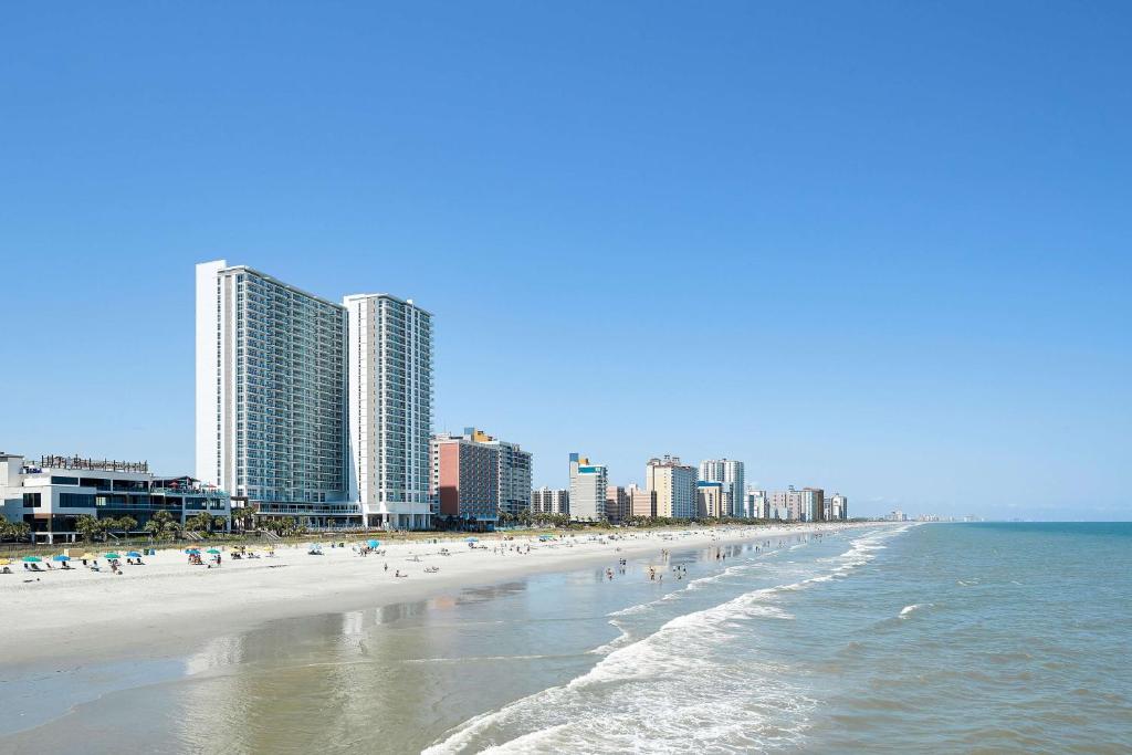 Ein Strand mit vielen Menschen und Gebäuden in der Unterkunft Hilton Grand Vacations Club Ocean Enclave Myrtle Beach in Myrtle Beach