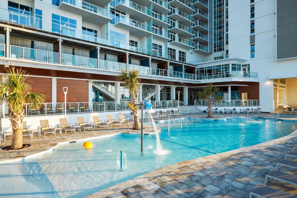 ein Schwimmbad mit Springbrunnen vor einem Gebäude in der Unterkunft Hilton Grand Vacations Club Ocean Enclave Myrtle Beach in Myrtle Beach