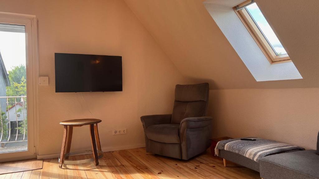uma sala de estar com uma cadeira e uma televisão de ecrã plano em Vindumi em Kirkel