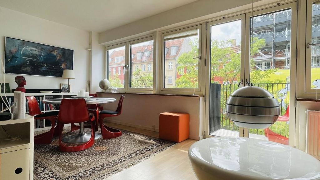 a living room with a table and chairs and windows at ApartmentInCopenhagen Apartment 139 in Copenhagen