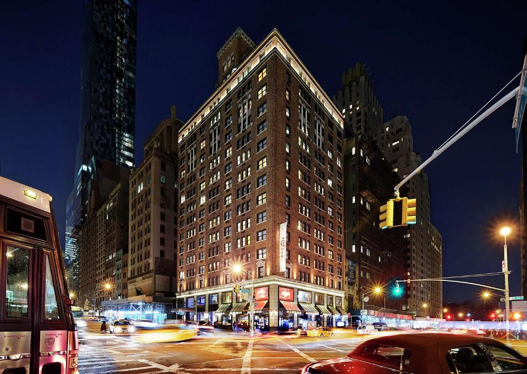 a large building on a city street at night at Hilton Club The Quin New York in New York