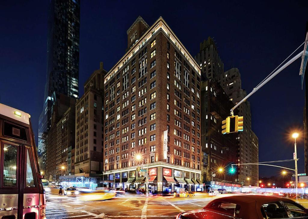 Hilton Club The Quin New York في نيويورك: مبنى كبير على شارع المدينة ليلا