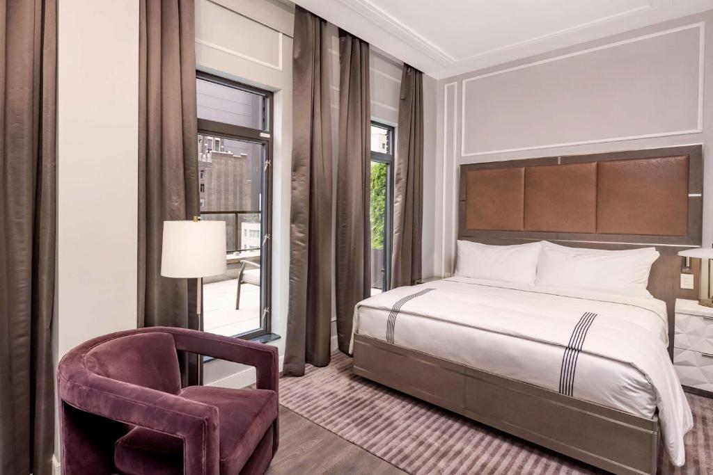 a bedroom with a bed and a chair and a window at Hilton Club The Quin New York in New York