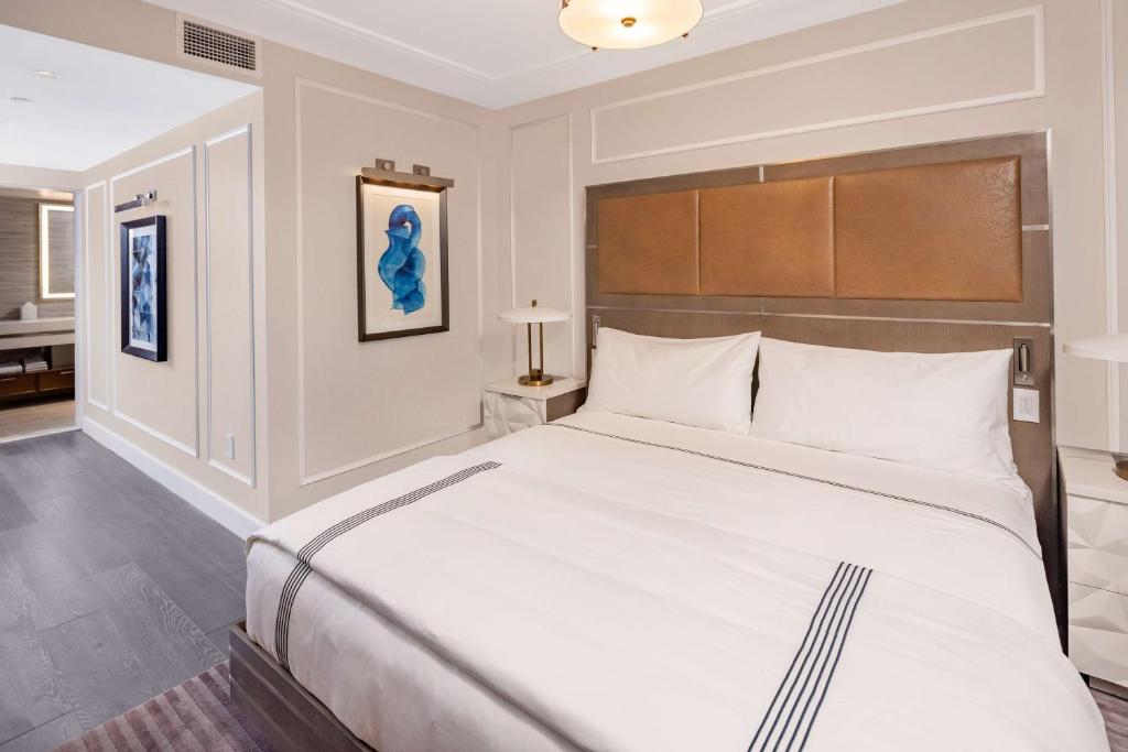 a bedroom with a large white bed in a room at Hilton Club The Quin New York in New York