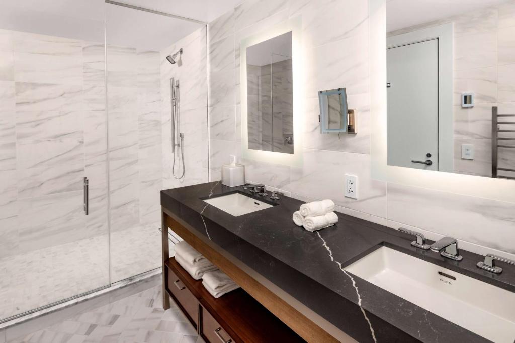 a bathroom with a sink and a large mirror at Hilton Club The Quin New York in New York