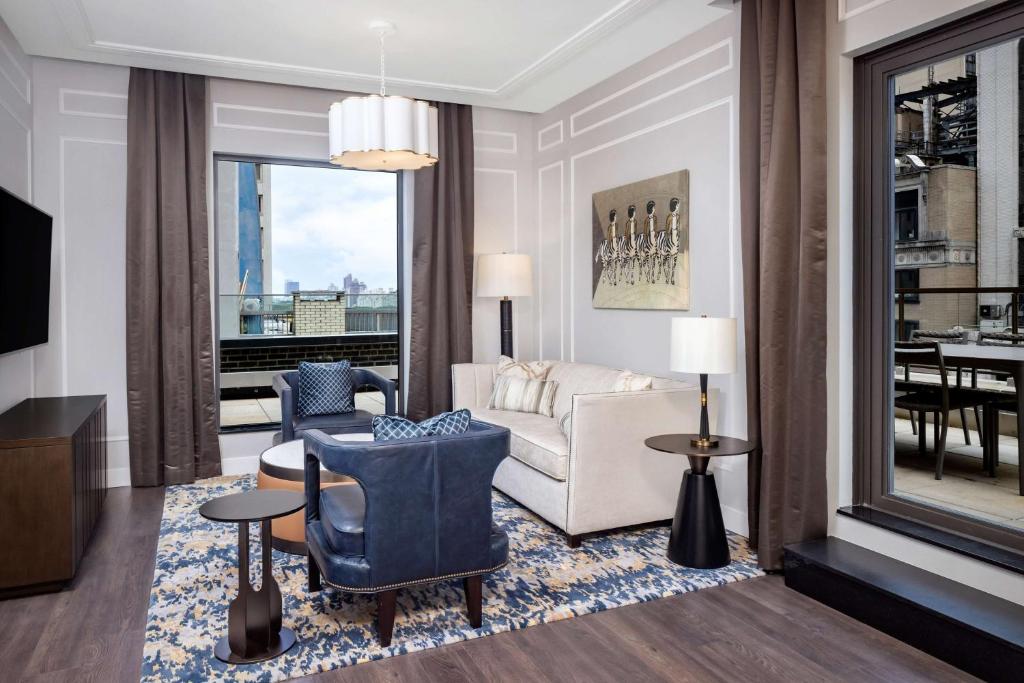 a living room with a couch and chairs and a table at Hilton Club The Quin New York in New York