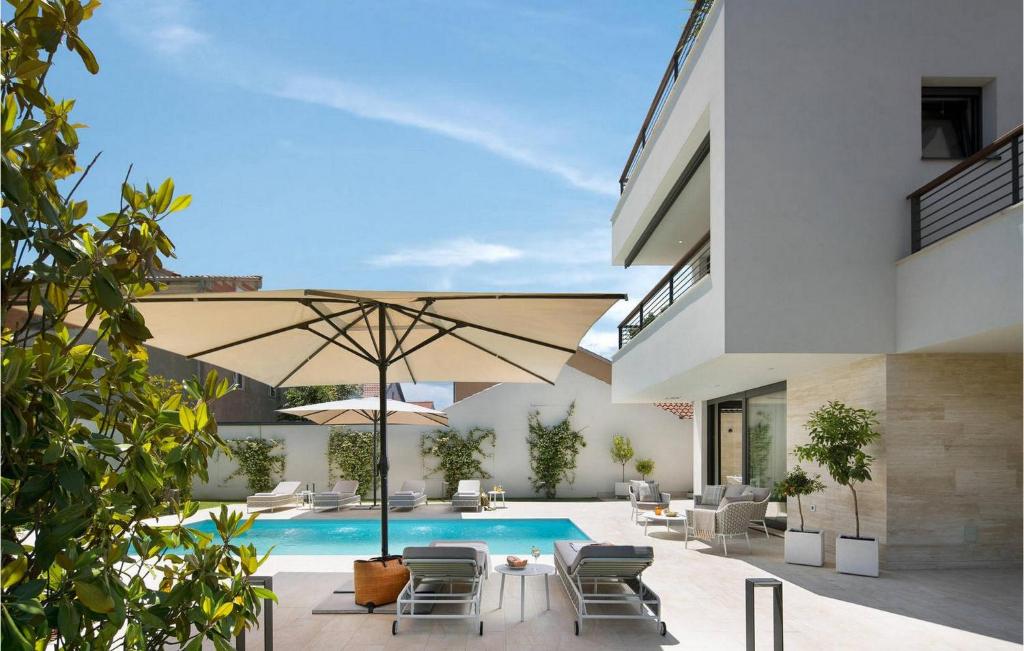 eine Terrasse mit einem Sonnenschirm und einem Pool in der Unterkunft Villa Tereza in Zadar
