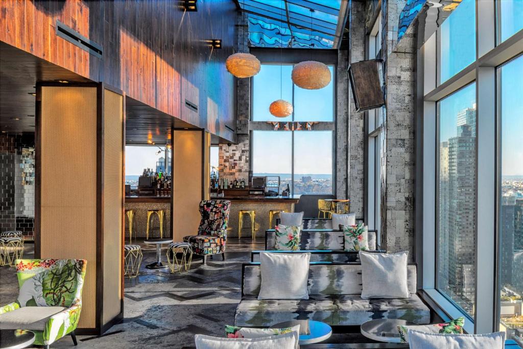 a lobby with tables and chairs and windows at Doubletree By Hilton New York Times Square West in New York