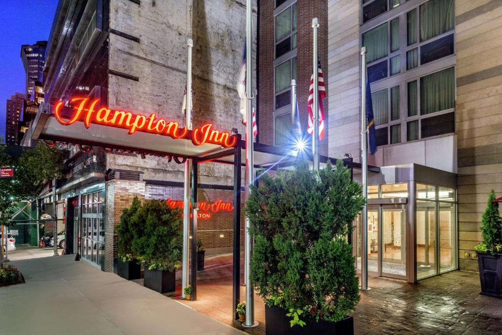 um sinal para uma estalagem Hampton em frente a um edifício em Hampton Inn Manhattan Grand Central em Nova Iorque