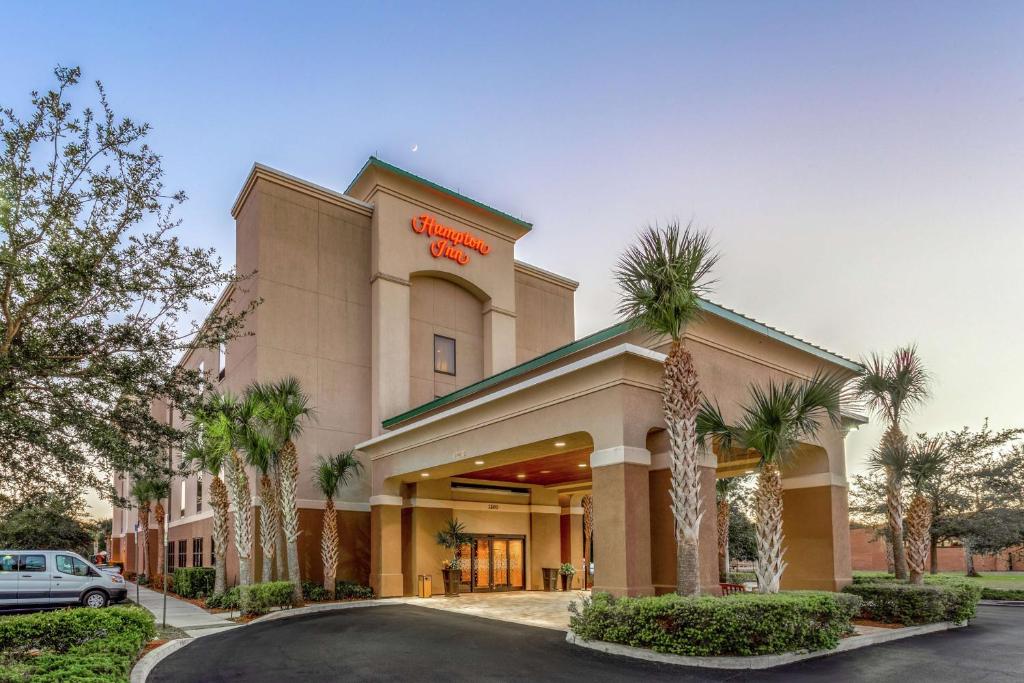a hotel with palm trees in front of a building at Hampton Inn Okeechobee - Lake Okeechobee in Okeechobee