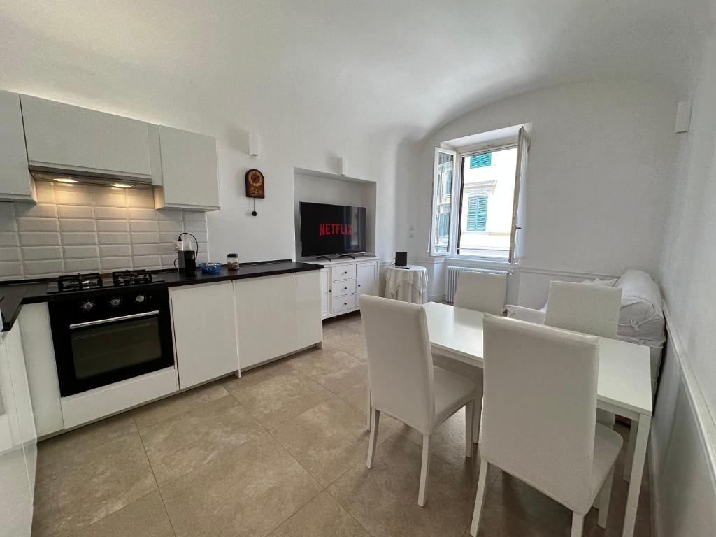 a kitchen with a table and white cabinets and a table and chairs at Apartment Centro Parioli in Rome