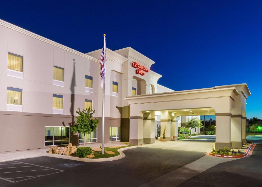 a hotel with an american flag in front of it at Hampton Inn Odessa in Odessa