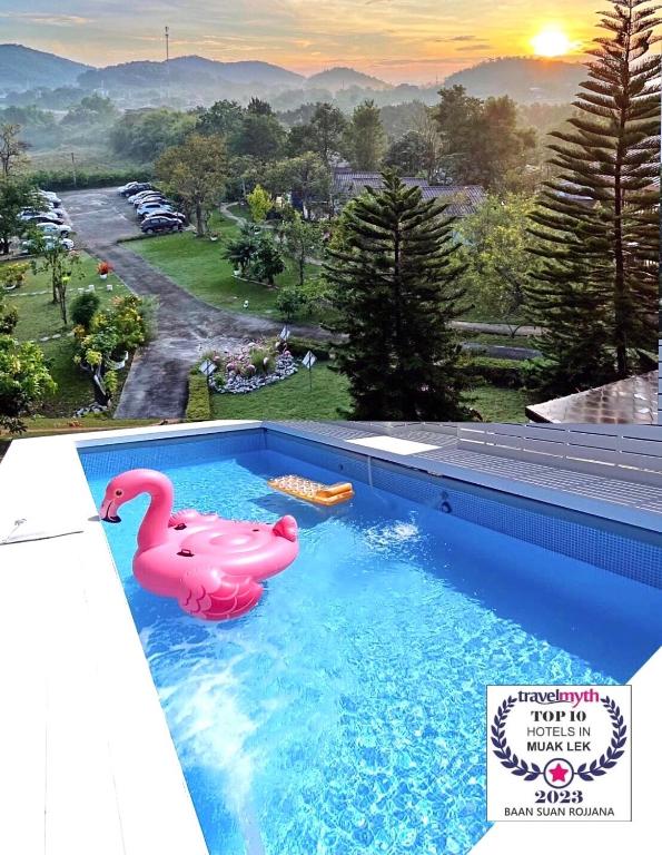 a swimming pool with a pink swan in the water at Baan Suan Rojjana in Muak Lek District