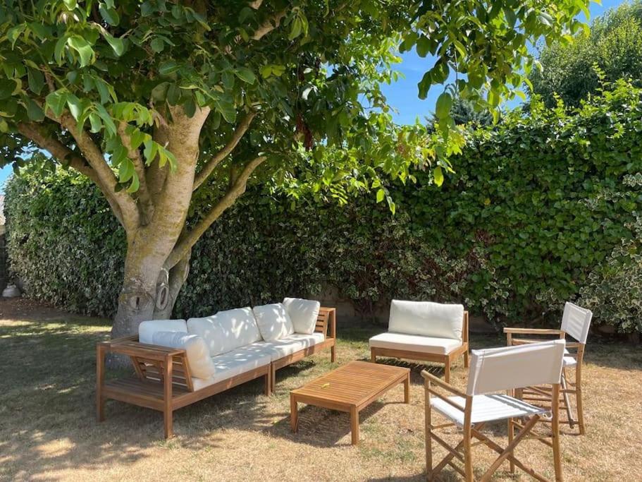 un canapé et des chaises assis sous un arbre dans l'établissement Maison Familiale idéale pour les Vacances/Weekends, à Dinard