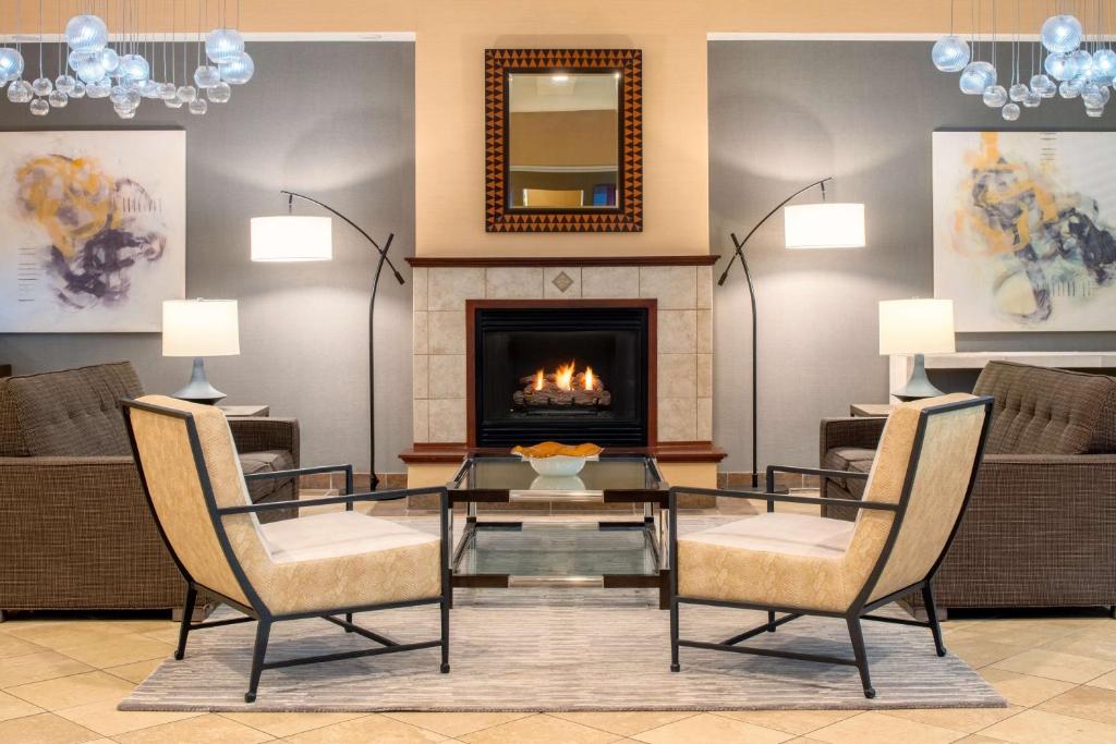 uma sala de estar com uma mesa de vidro e uma lareira em DoubleTree by Hilton Olympia em Olympia