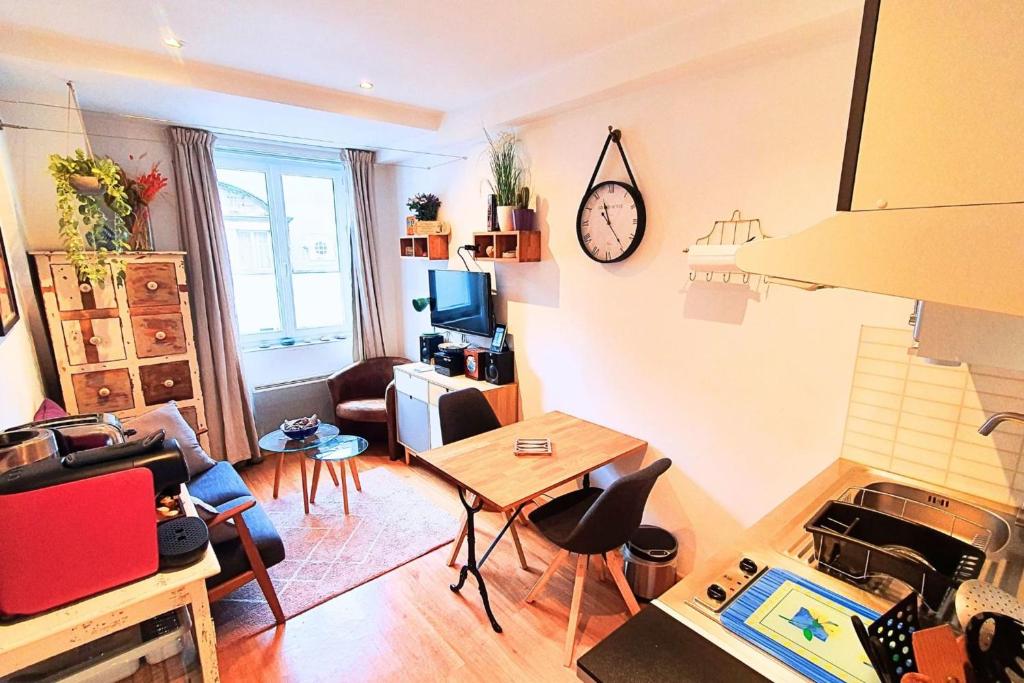 - un salon avec une table, des chaises et une horloge dans l'établissement Haven of peace near the beaches in Saint-Malo, à Saint-Malo