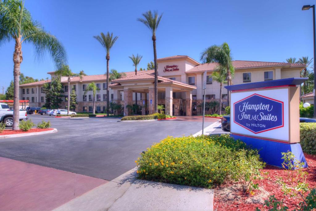 un hotel con un cartel delante de un estacionamiento en Hampton Inn & Suites Ontario, en Ontario