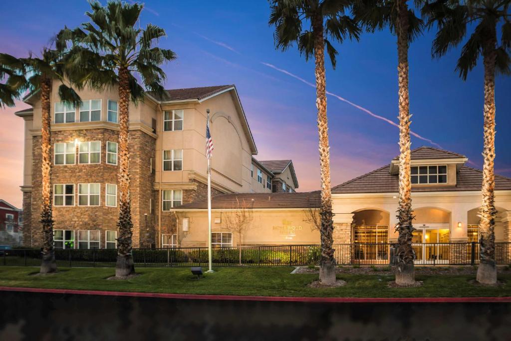 a building with palm trees in front of it at Homewood Suites by Hilton Ontario Rancho Cucamonga in Rancho Cucamonga