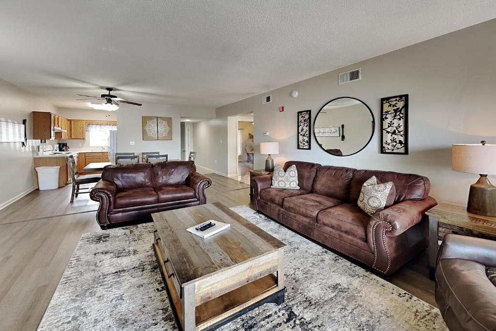 a living room with leather couches and a table at Rock-a-While Whispering Pines 214 in Pigeon Forge