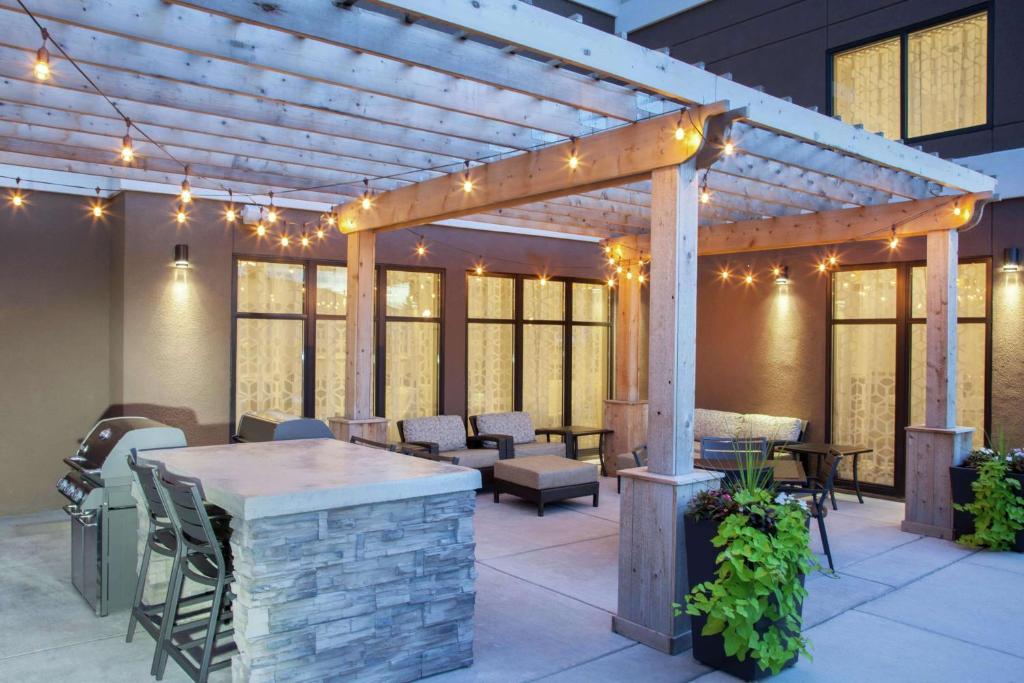 a patio with a wooden pergola with lights at Homewood Suites by Hilton Munster in Munster