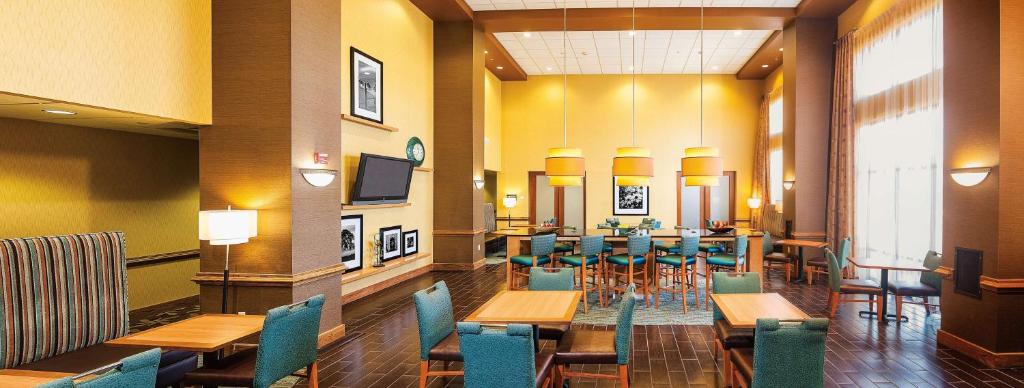 - Zona de comedor con mesas y sillas en un edificio en Hampton Inn & Suites Chesapeake-Square Mall, en Chesapeake