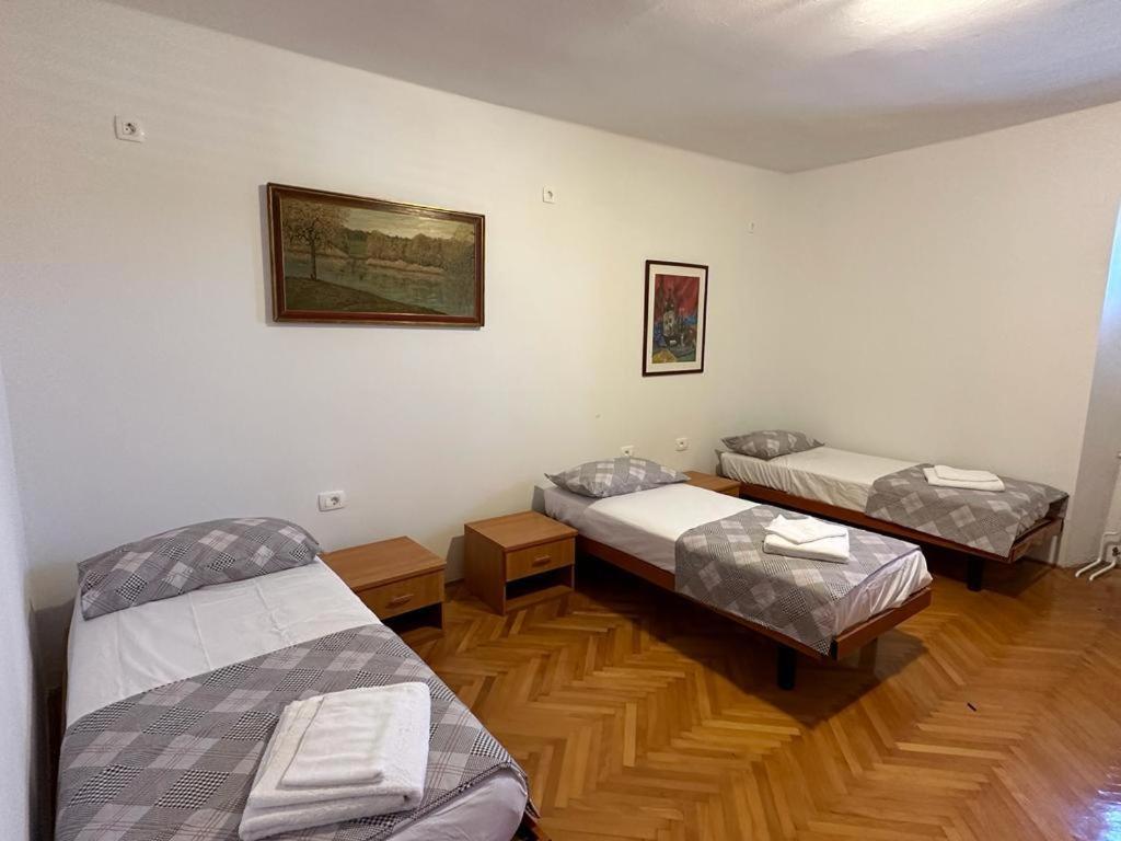 Habitación con 3 camas y suelo de madera. en Hostel on the road trip, en Materija
