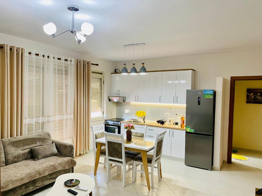 a kitchen and living room with a table and a refrigerator at ALBI’S Apartment in Tirana
