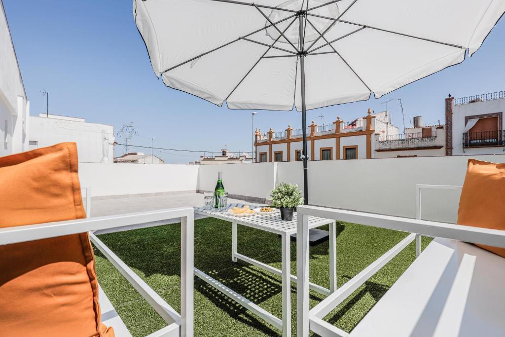 a white balcony with a table and an umbrella at Algaba Severo Ochoa 1 in La Algaba