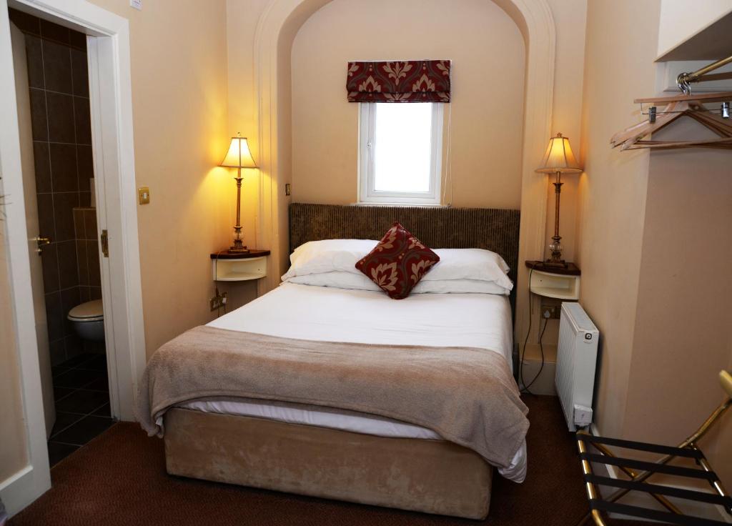 a small bedroom with a bed and a window at Gabriel House Guesthouse in Cork