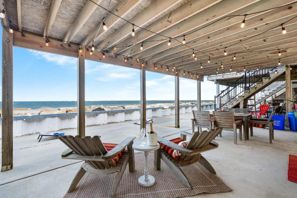 a patio with chairs and a table on the beach at Waterfront North Wildwood Anglesea Family Retreat in North Wildwood