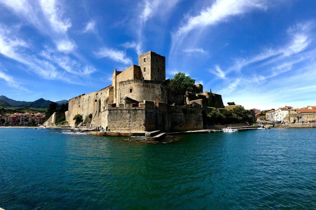 un vieux château au milieu d'une masse d'eau dans l'établissement Lumières à Collioure, à Collioure