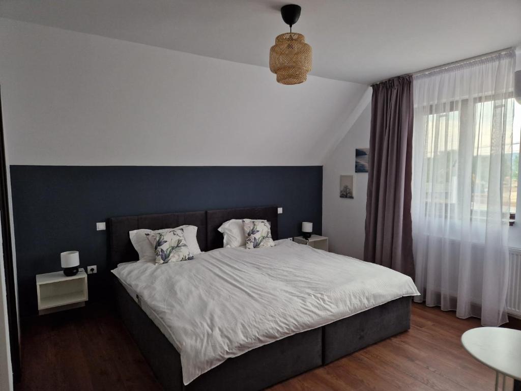 - une chambre avec un grand lit et un mur bleu dans l'établissement Pensiunea Vlad, 