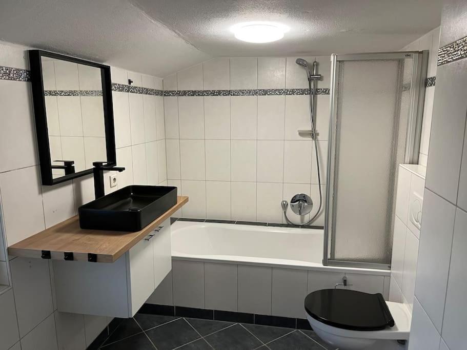 uma casa de banho com um lavatório, um WC e uma banheira em Monteurwohnung in Kassel em Niestetal