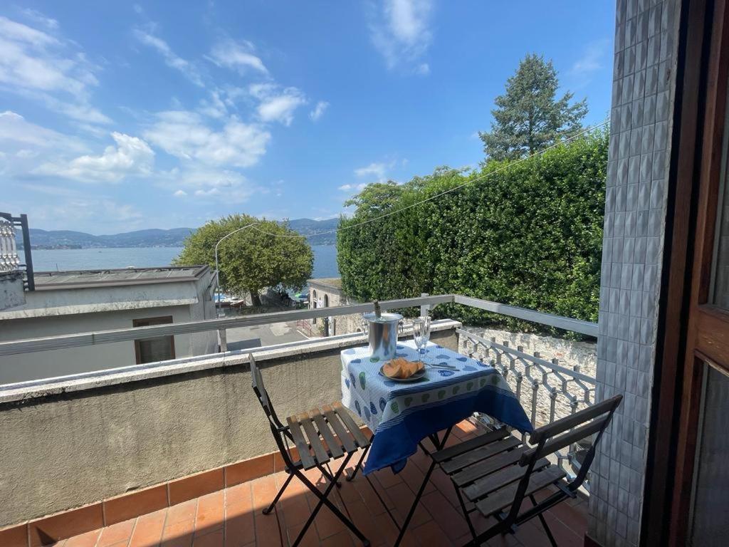 una mesa y sillas en un balcón con vistas en Margherita lake view Apartment en Ispra