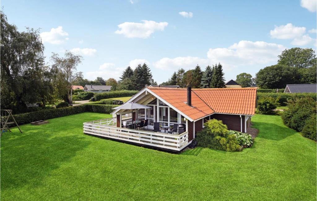 dom z pomarańczowym dachem na zielonym trawniku w obiekcie Nice Home In Sydals With Sauna w mieście Skovby