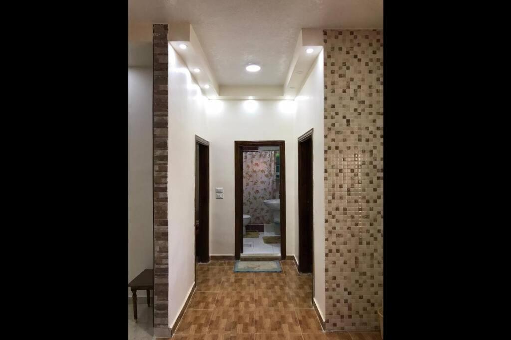 a hallway with a tile wall and a hallway with a mirror at Your cozy apartment in Al-Karak in Kerak