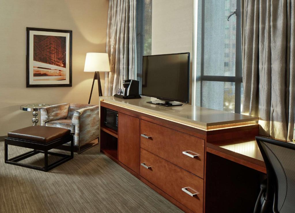 a hotel room with a television on a desk with a chair at Hilton Garden Inn Phoenix Downtown in Phoenix