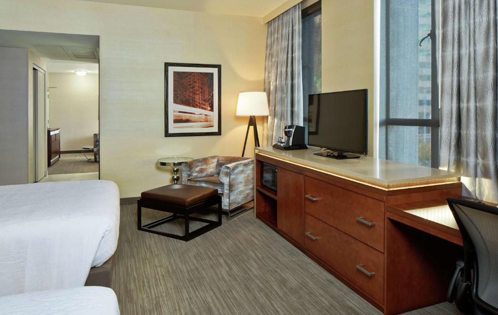 a hotel room with a bed and a flat screen tv at Hilton Garden Inn Phoenix Downtown in Phoenix