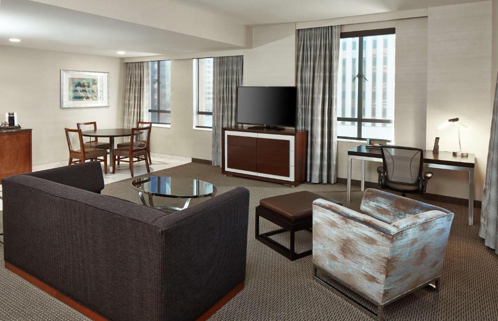 a living room with a couch and a chair and a tv at Hilton Garden Inn Phoenix Downtown in Phoenix