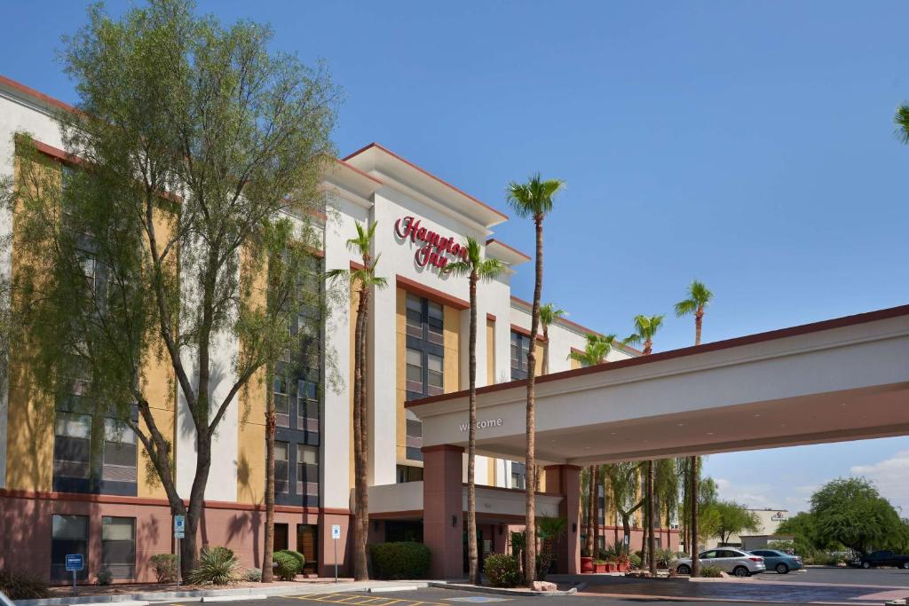 a hotel with palm trees in front of a building at Hampton Inn Glendale-Peoria in Peoria