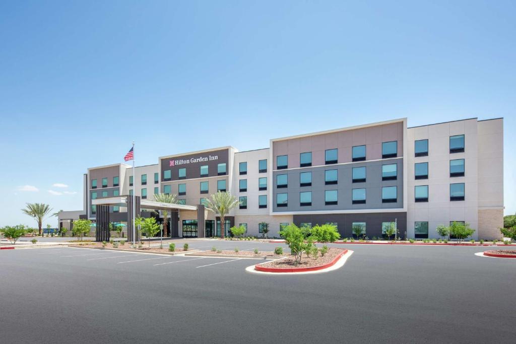 un edificio de oficinas con un estacionamiento delante de él en Hilton Garden Inn Surprise Phoenix, en Surprise