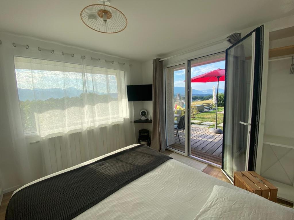 Un dormitorio con una cama y vista a un balcón. en FalHappy House, en Poisy