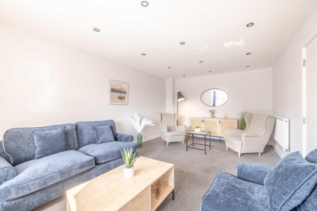 a living room with a blue couch and chairs at Spacious 4 Bed - Near Uxbridge/Heathrow & PARKING in Slough