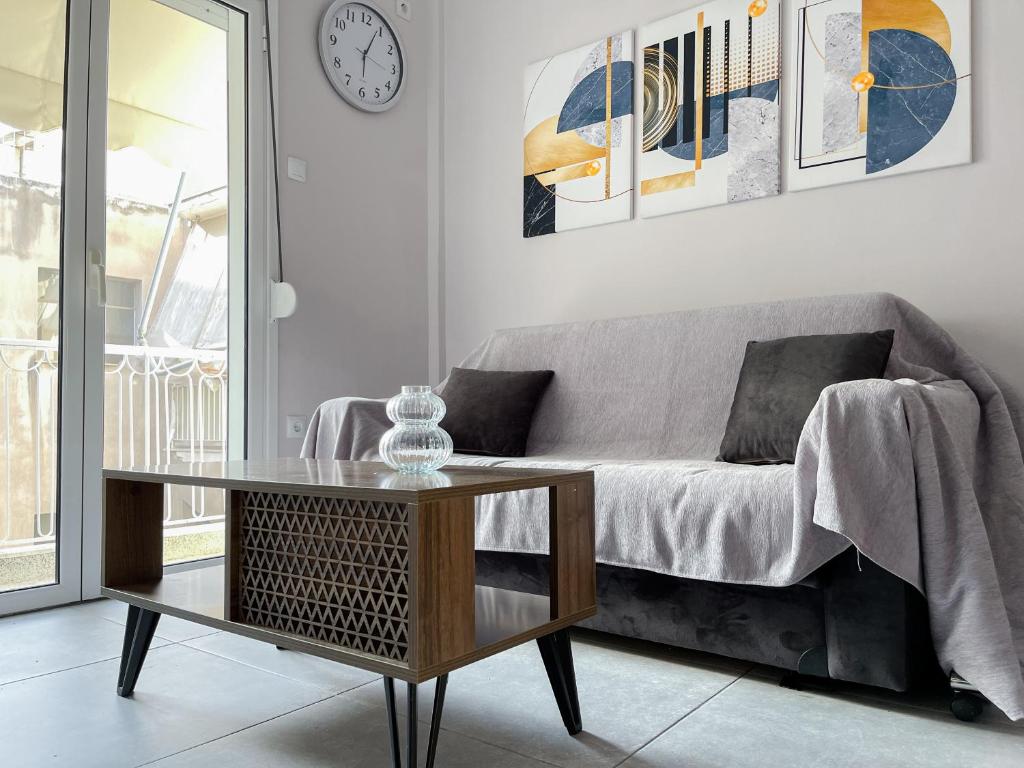 uma sala de estar com um sofá e uma mesa de vidro em 2-bedroom Winter Apartment em Atenas