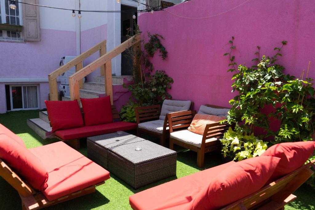 um pátio com mobiliário vermelho e uma parede roxa em Ajami Guest House em Tel Aviv