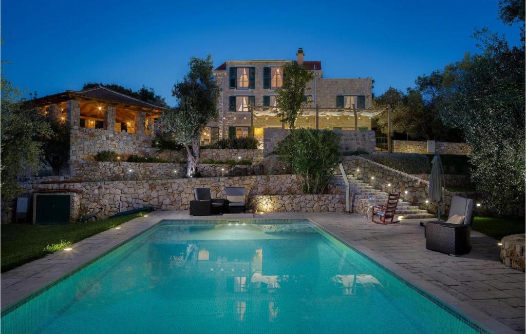 a swimming pool in front of a house at Villa Stella Maris in Suđurađ